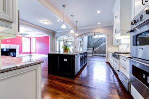 Large interior kitchen with pendant lights, island, and two ovens.